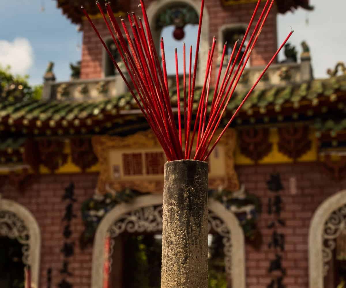 Hoi An tour of the old city, incense in focus in front of temple entrance