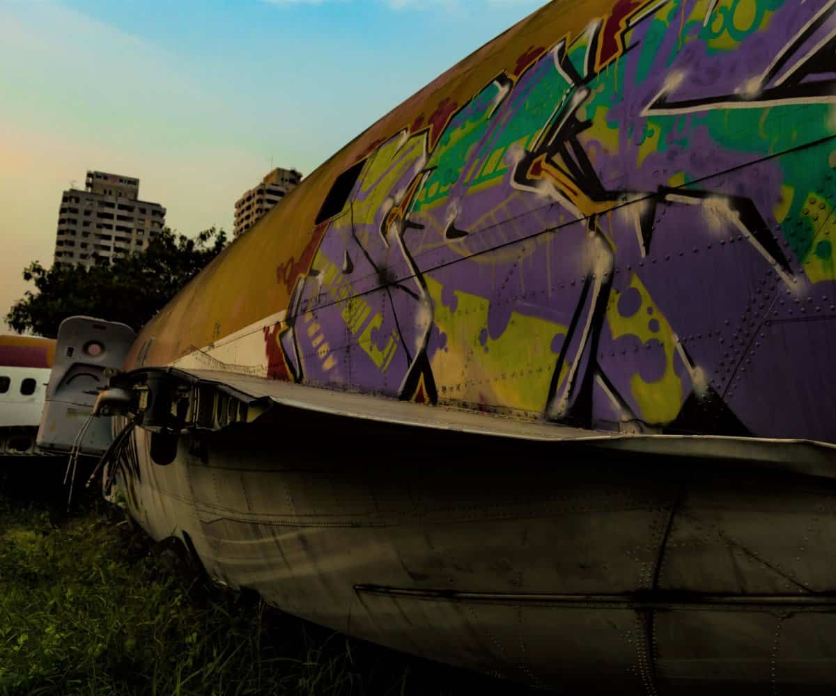 The colorful, graffiti skin of a plane laid to rest inside Bangkok, Thailand.