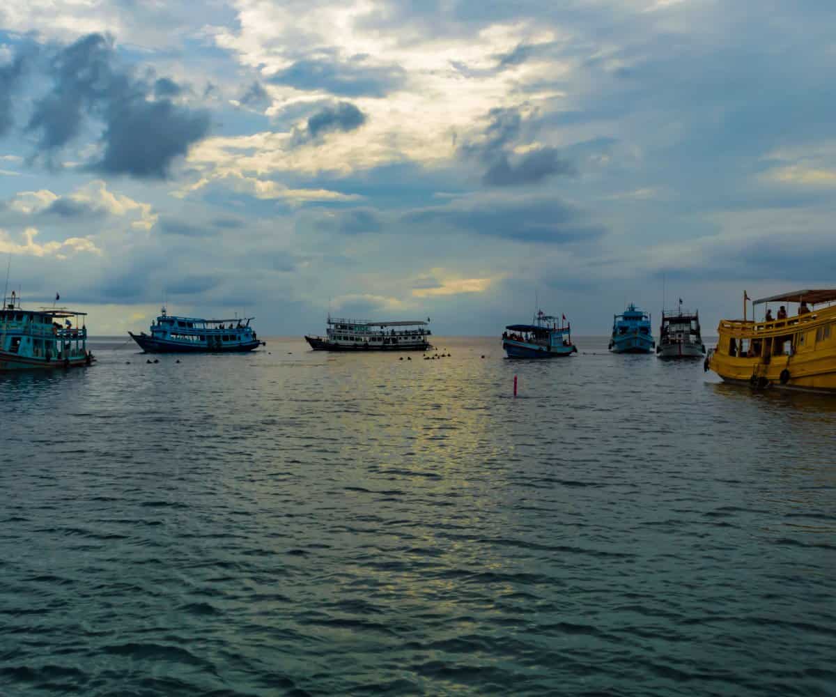 A semi-circle of anchored boats waiting for divers to surface, Koh Tao, Thailand.