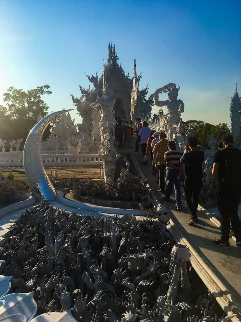Tourists being hurried through Wat Rong Khun Temple complex before closing time of 5 p.m., Chiang Rai, Thailand