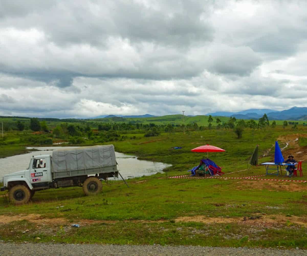MAG setting up around a potential UXO along a secondary road, Phonsavan, Laos