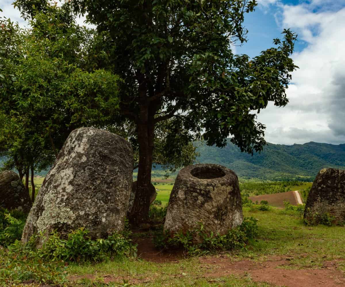 Laos' unique Plain of Jars stands with jungle mountains in the background