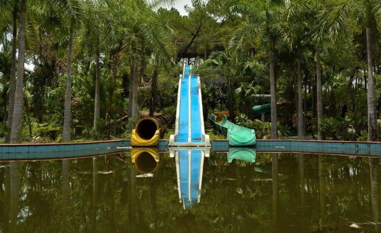 Water slides reflect off a stale pool of water in Ho Thuy Tien