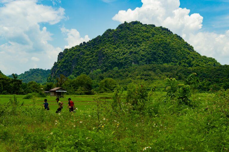 Young fishermen return home through the hills in Muang Ngoy