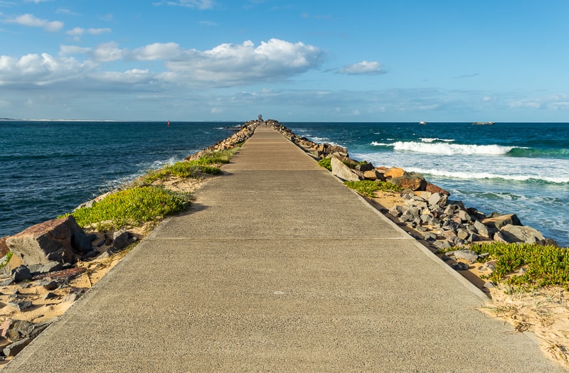 Newcastle Breakwall extends out the back of Nobby's Lighthouse
