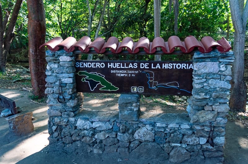 Sendero Huellas de la Historia sign makes the beginning of the trail to El Cubano Waterfall